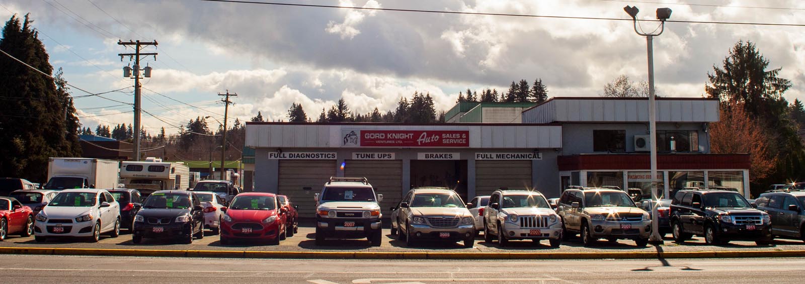 Car dealer with lots of cars and trucks for sale.